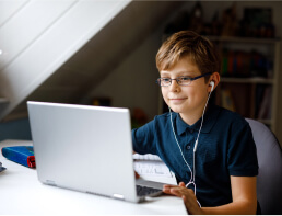 Boy with glasses learning at home on laptop